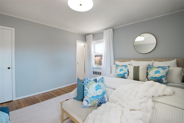 living area with baseboards, wood finished floors, and crown molding