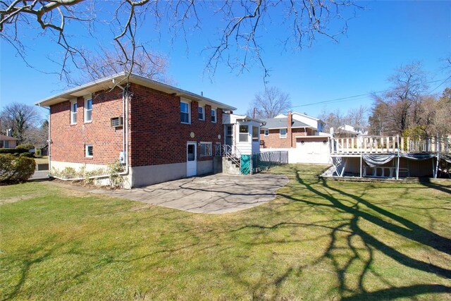 back of house with a patio, a yard, a pool, and brick siding