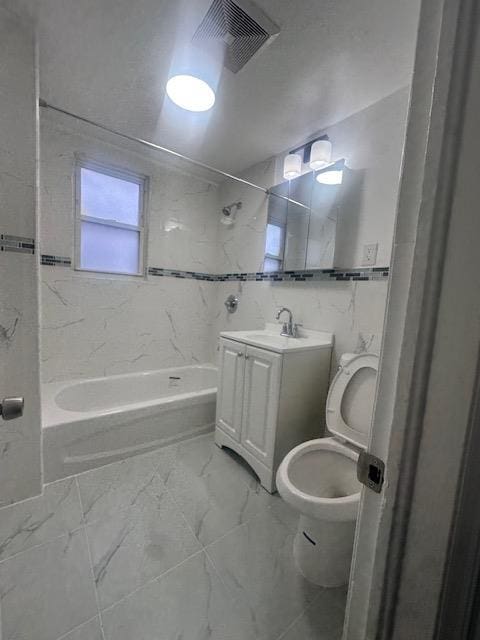 full bath with visible vents, toilet, marble finish floor, tile walls, and tub / shower combination