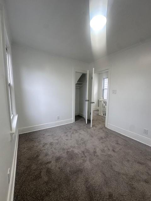 unfurnished bedroom with a closet, baseboards, and carpet flooring