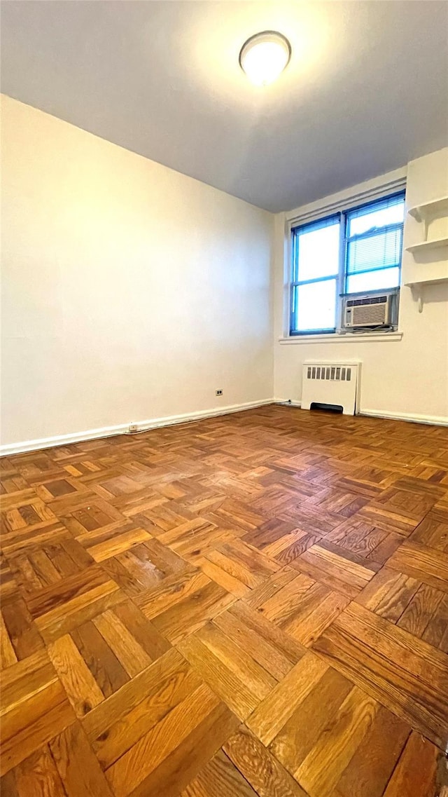 spare room featuring cooling unit, baseboards, and radiator