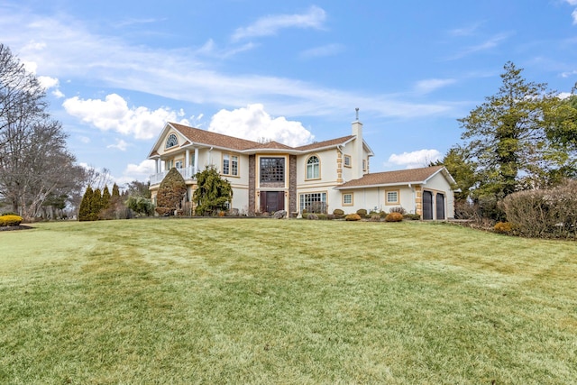 view of front of home featuring a front lawn, stucco siding, a chimney, a garage, and a balcony