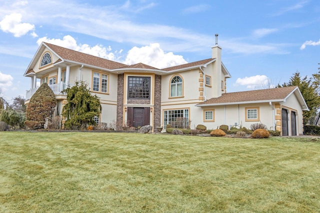 view of front of property with stucco siding, an attached garage, a chimney, and a front yard