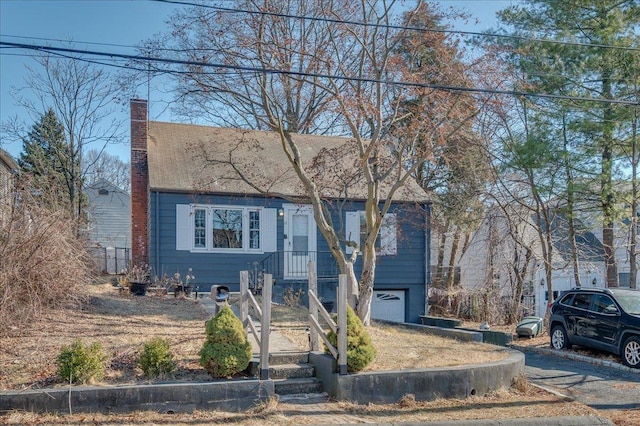 view of front of house featuring an attached garage and a chimney