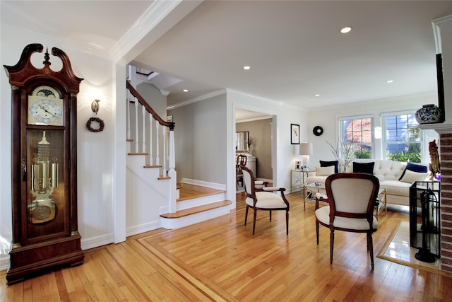 entrance foyer with light wood-style flooring, stairs, baseboards, and ornamental molding