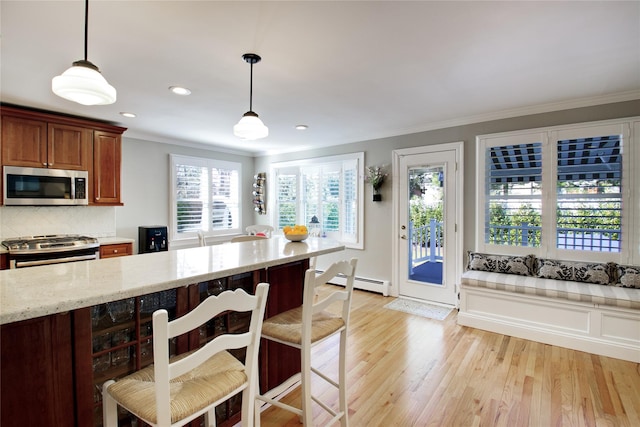 kitchen with light stone counters, light wood-style floors, appliances with stainless steel finishes, crown molding, and decorative backsplash