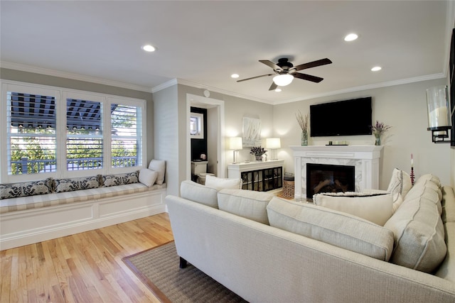 living room with recessed lighting, wood finished floors, a high end fireplace, and ornamental molding