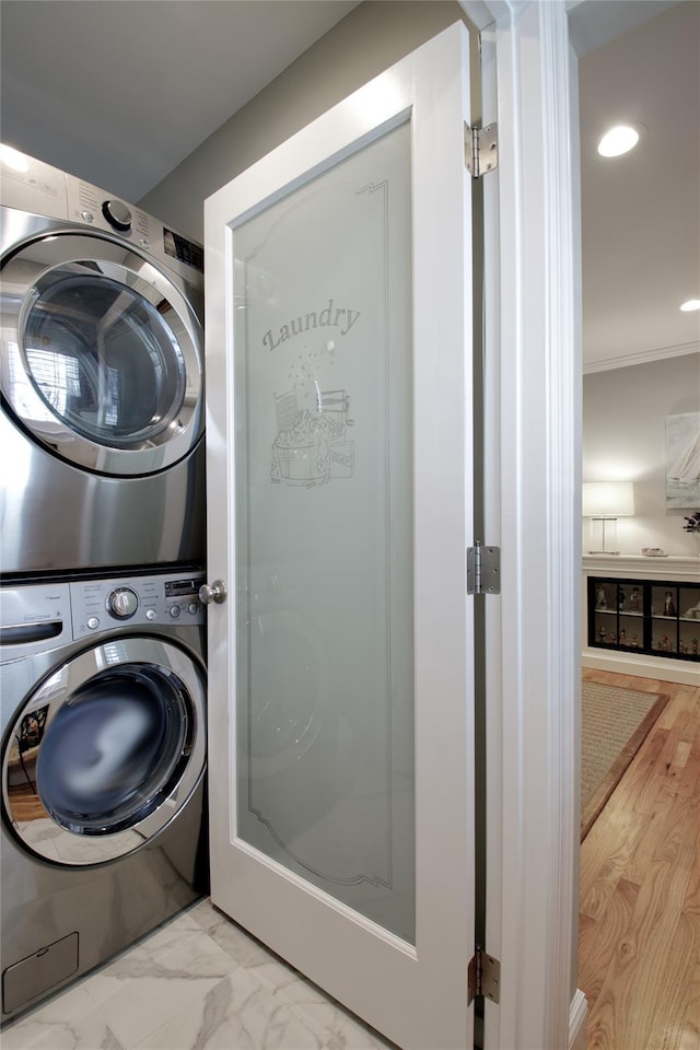 washroom with stacked washer / dryer, ornamental molding, laundry area, recessed lighting, and marble finish floor