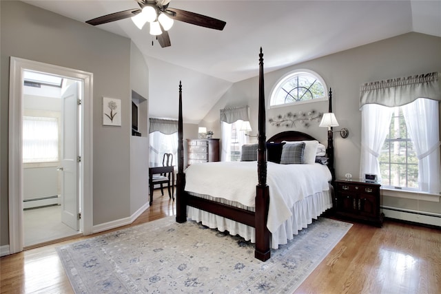 bedroom with a baseboard radiator, lofted ceiling, and multiple windows