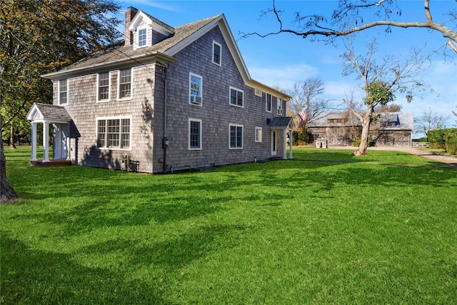 view of side of property featuring a chimney and a yard