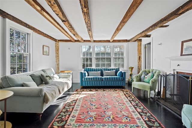 living room featuring beamed ceiling, wood finished floors, and a fireplace