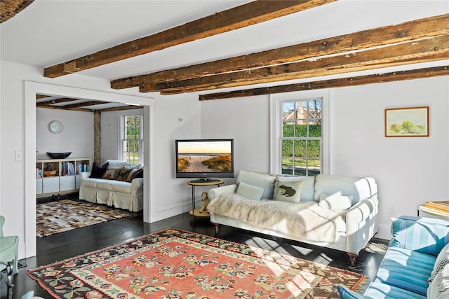 living room featuring dark wood finished floors, beam ceiling, plenty of natural light, and baseboards