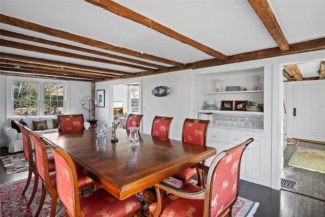 dining space featuring dark wood-type flooring, plenty of natural light, built in shelves, and beam ceiling