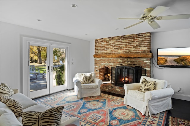 living room featuring french doors, baseboards, a brick fireplace, and wood finished floors