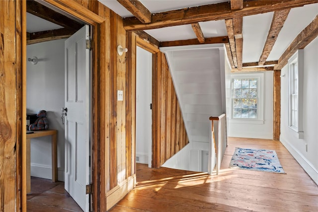 hallway featuring beamed ceiling and wood-type flooring
