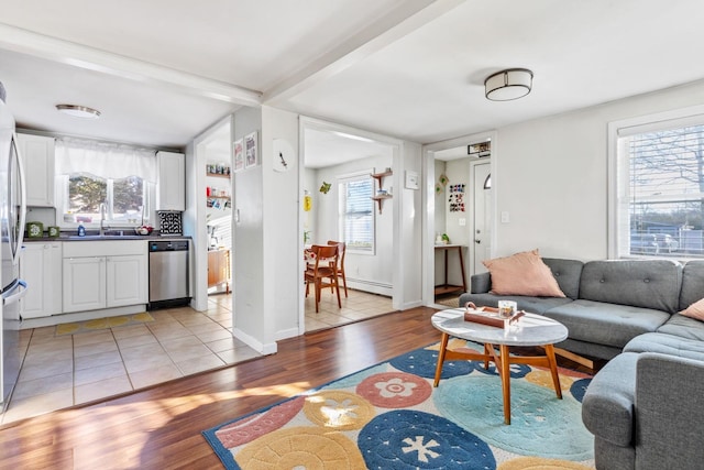 living room with light wood-type flooring, baseboards, and a baseboard radiator