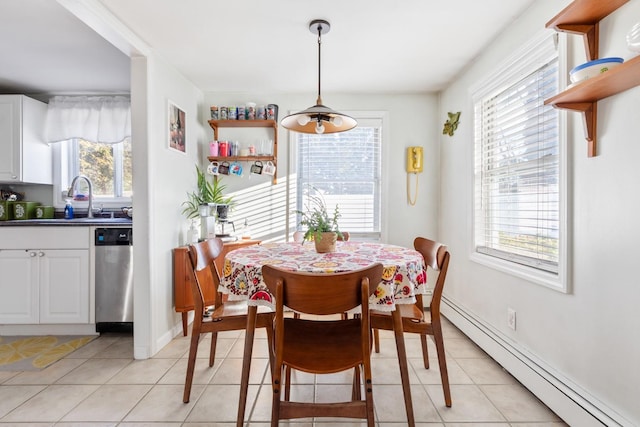 dining room with a baseboard heating unit, light tile patterned floors, and baseboards