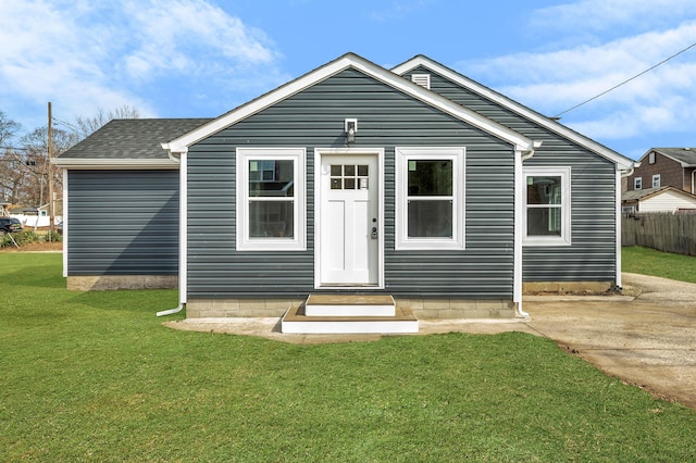 bungalow featuring a front yard, fence, and roof with shingles