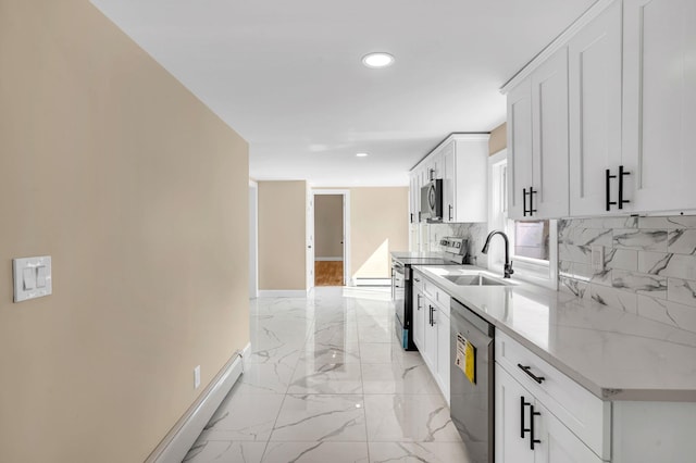 kitchen with baseboards, a sink, marble finish floor, appliances with stainless steel finishes, and tasteful backsplash