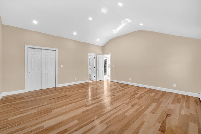 interior space featuring recessed lighting, light wood-type flooring, lofted ceiling, and baseboards