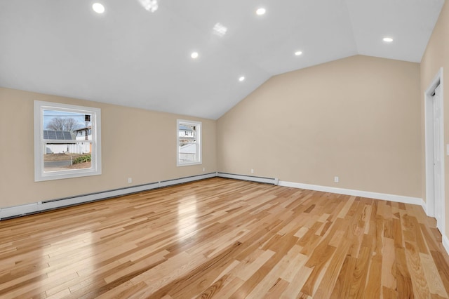 empty room featuring a baseboard heating unit, lofted ceiling, light wood-style floors, and baseboards