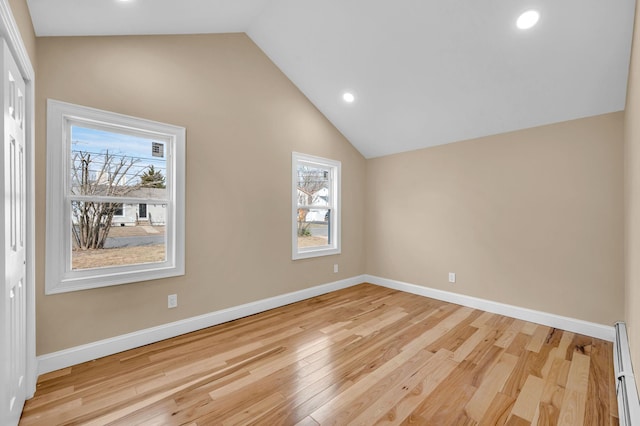 interior space featuring light wood-type flooring, a baseboard heating unit, recessed lighting, baseboards, and vaulted ceiling