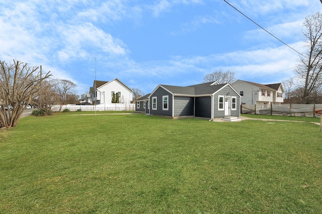 back of property with a lawn, a fenced backyard, and entry steps