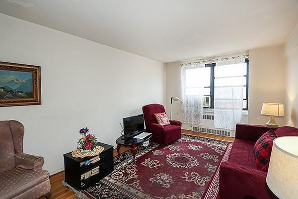 living room with wood finished floors and radiator heating unit