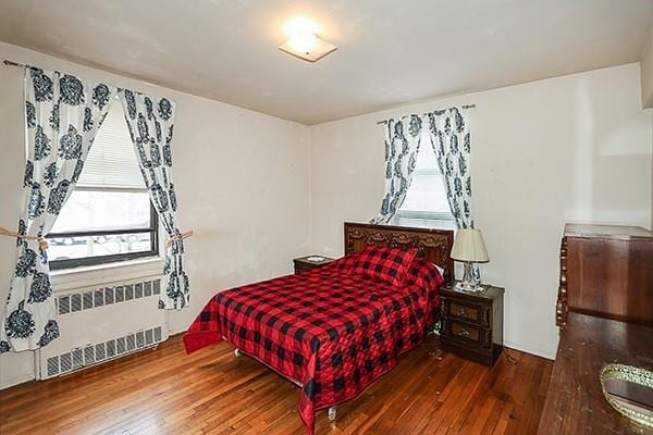 bedroom featuring hardwood / wood-style floors and radiator heating unit