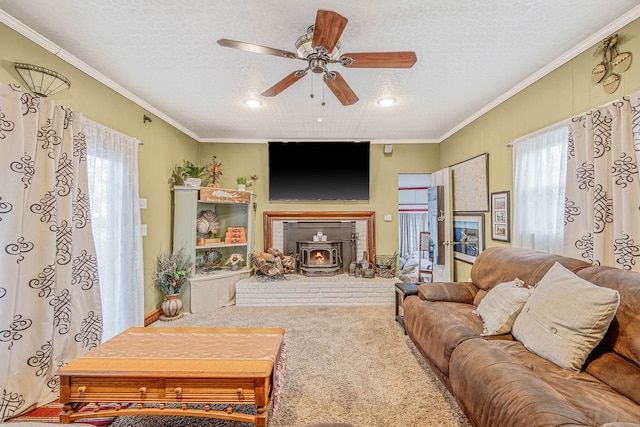 carpeted living room featuring crown molding, a textured ceiling, a wood stove, and ceiling fan