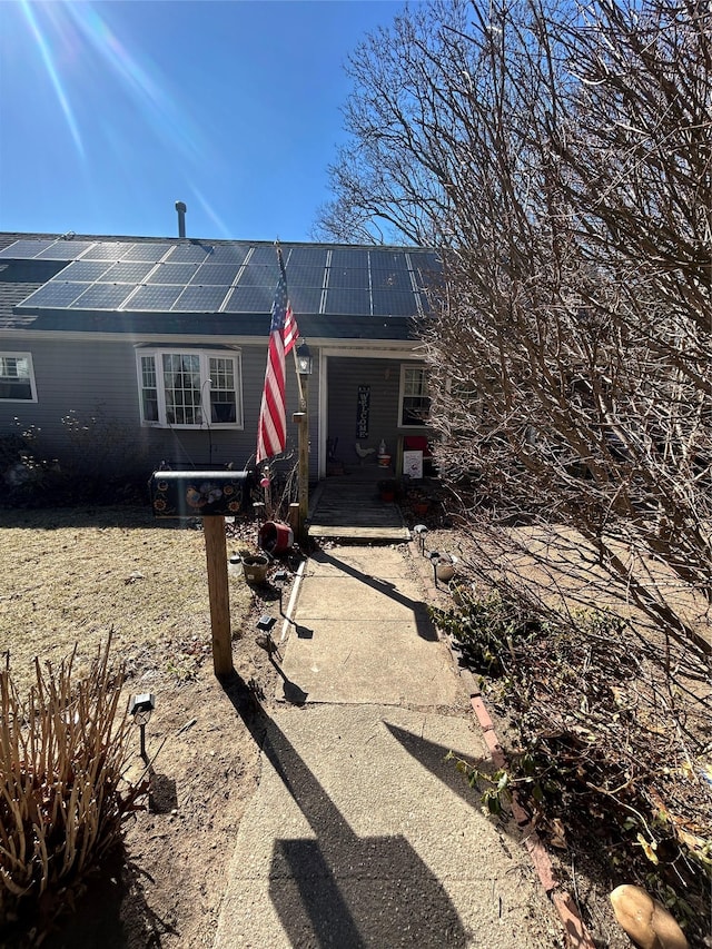 view of exterior entry featuring roof mounted solar panels