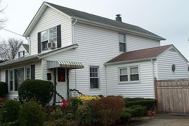 view of home's exterior with a chimney and fence