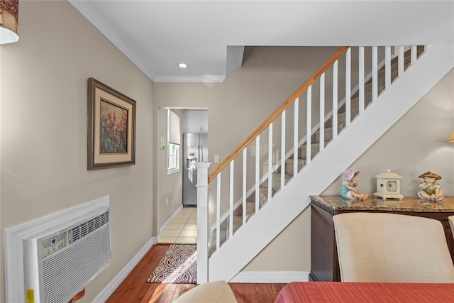724 Thrush Ave, West Hempstead, NY 11552 - foyer entrance featuring stairway, a wall unit AC, baseboards, ornamental molding, and wood finished floors