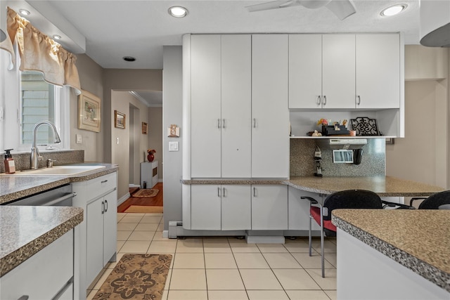 724 Thrush Ave, West Hempstead, NY 11552 - kitchen featuring a sink, decorative backsplash, white cabinetry, light tile patterned floors, and a ceiling fan