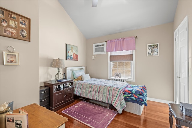 724 Thrush Ave, West Hempstead, NY 11552 - bedroom featuring dark wood-type flooring, an AC wall unit, vaulted ceiling, baseboards, and ceiling fan