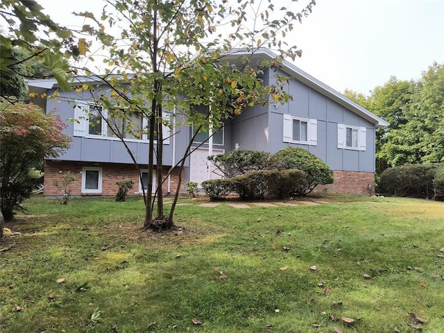 view of side of home with brick siding, board and batten siding, and a lawn