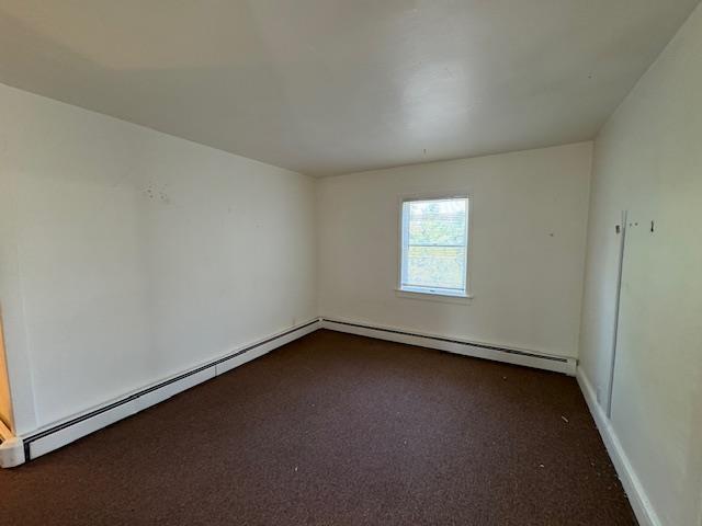 64 Rosman Rd, Thiells, NY 10984 - empty room featuring a baseboard heating unit and dark colored carpet