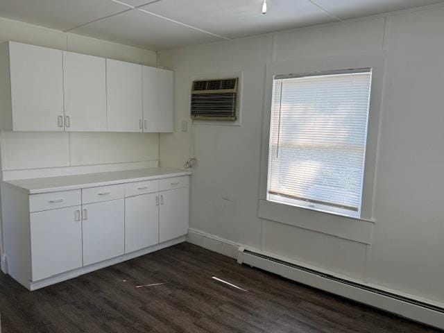 64 Rosman Rd, Thiells, NY 10984 - kitchen featuring white cabinets, light countertops, dark wood-type flooring, a baseboard heating unit, and a wall mounted AC