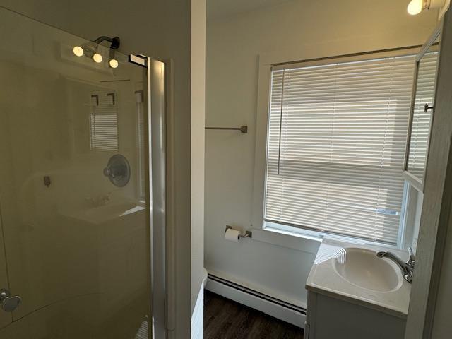 64 Rosman Rd, Thiells, NY 10984 - full bath featuring vanity, wood finished floors, a baseboard heating unit, and a shower stall