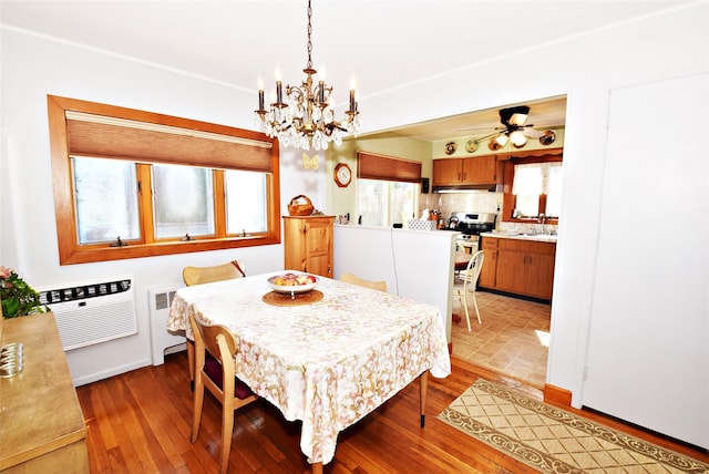 dining room featuring plenty of natural light, wood finished floors, and a wall mounted air conditioner