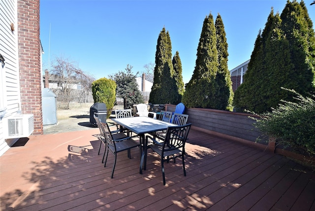 wooden deck with outdoor dining space and fence