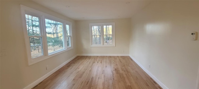 unfurnished room with light wood-style flooring and baseboards