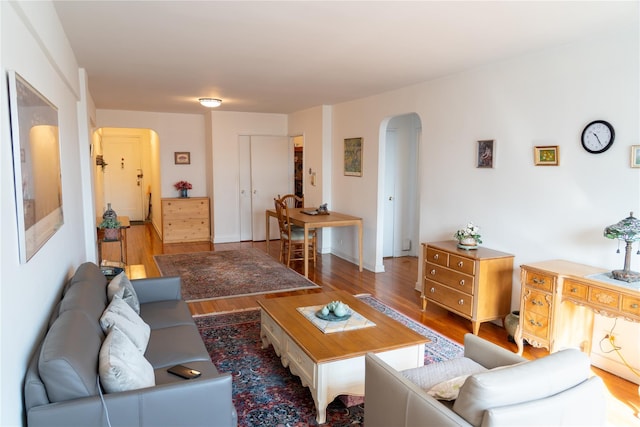 living room featuring arched walkways and wood finished floors