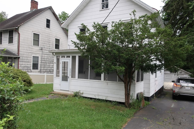 exterior space with a front lawn and a sunroom