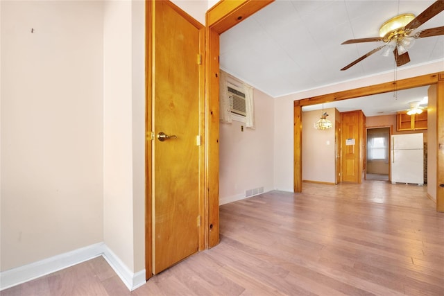 spare room with visible vents, ceiling fan, baseboards, a wall mounted air conditioner, and light wood-style floors