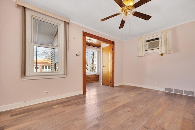 unfurnished room featuring visible vents, wood finished floors, baseboards, and ornamental molding