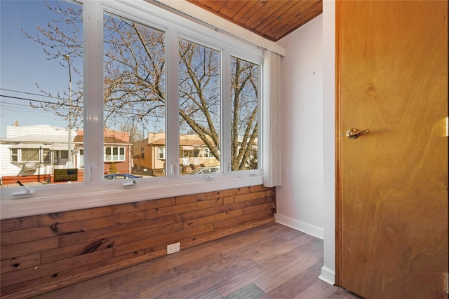 interior space with baseboards, wood finished floors, and wooden ceiling