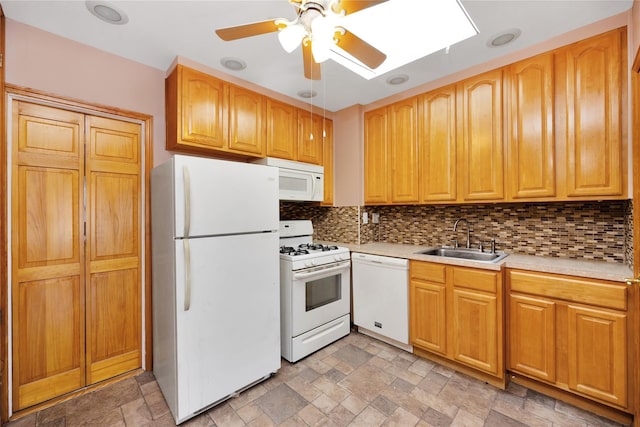 kitchen with stone finish floor, a sink, backsplash, white appliances, and light countertops