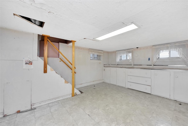 below grade area featuring light floors and a textured ceiling