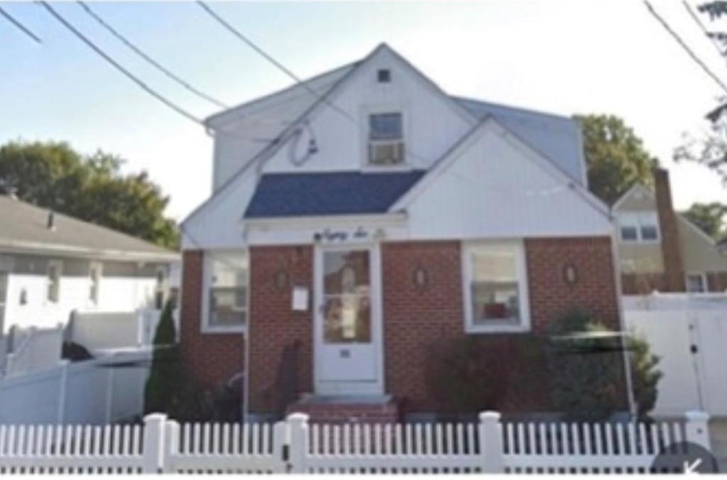 bungalow-style home with a fenced front yard and brick siding